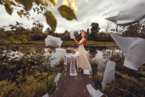 Woman Stands Bridge Front Lake Is Surrounded By Paper Sheets (1)