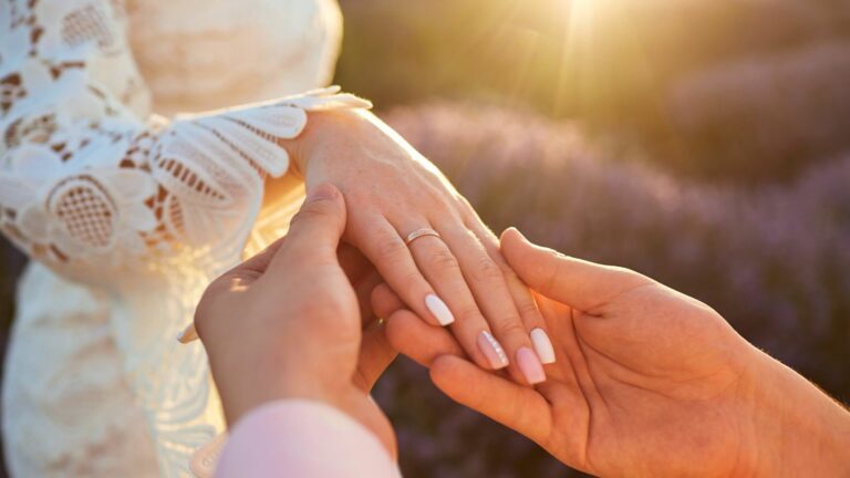 organisation de mariage en Provence : mariés dans un champ de lavande avec gros plan sur l'alliance de la mariée
