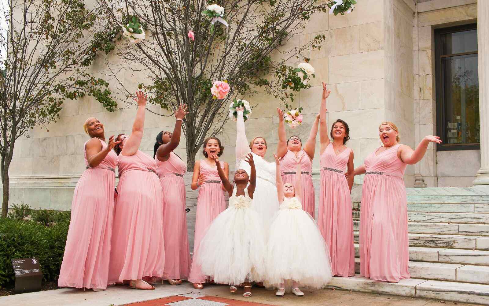 Robes de demoiselles d'honneur roses avec la mariée lançant son bouquet