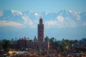 Une vue panoramique de Marrakech avec la mosquée Koutoubia en premier plan et l' Atlas enneigé en arrière-plan