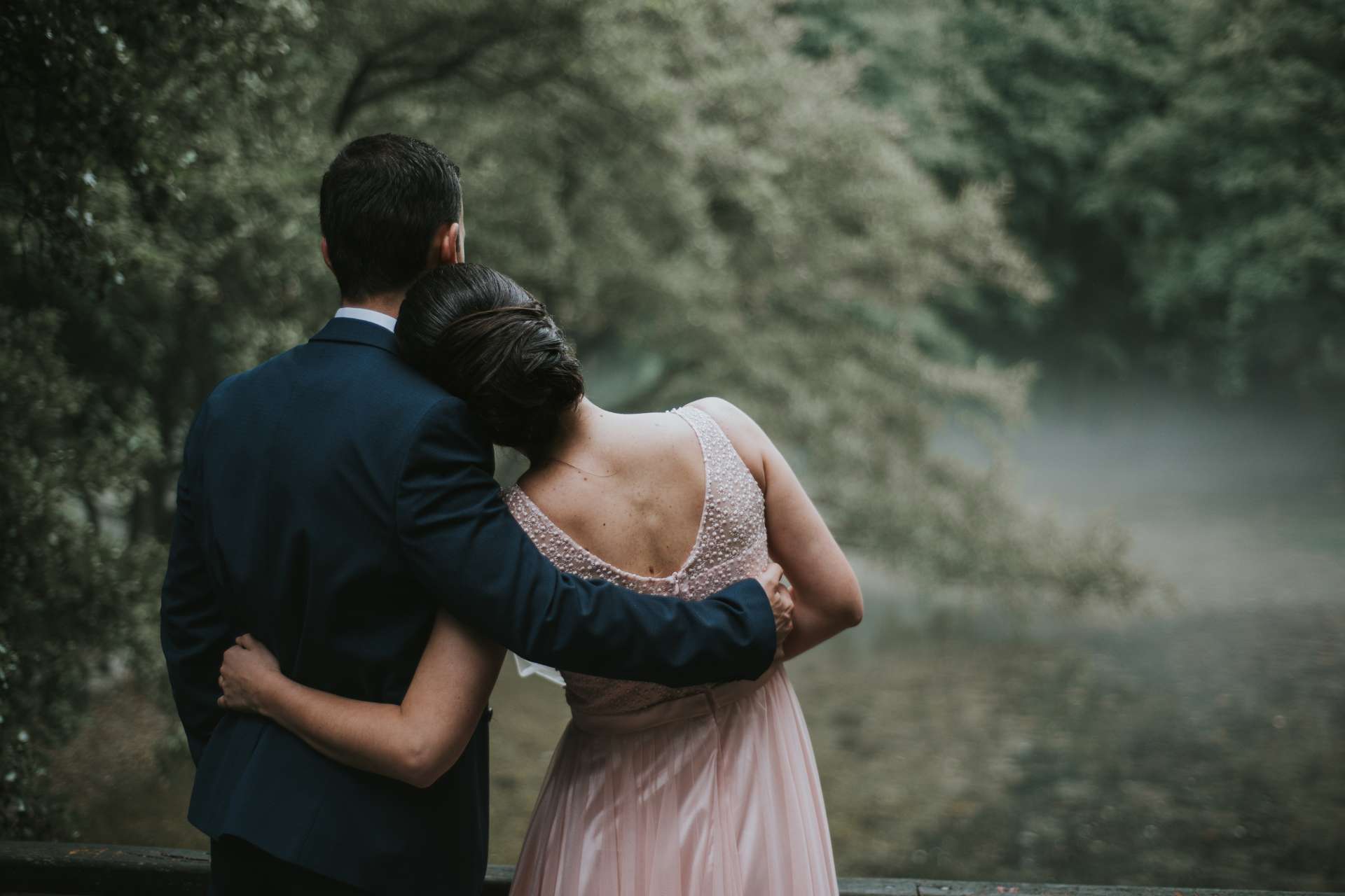 Couple de marié se tenant dans les bras l'un de l'autre regardant la nature